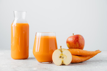Detox drink in glass jar, slice of apple and carrot on white background. Refreshed homemade natural...