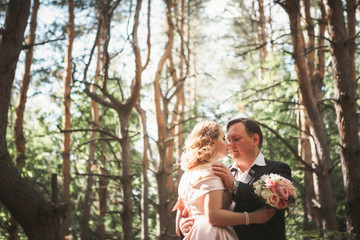 bride and groom on the background of trees and woods in full growth