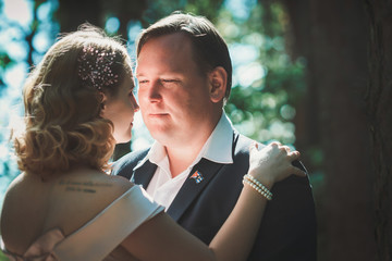 bride and groom on the background of trees and forest sun