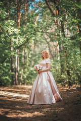 Obraz na płótnie Canvas portrait of a beautiful bride standing near a tree