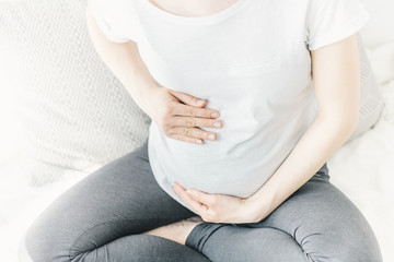 Young pregnant woman touching her belly
