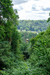 Fototapeta na wymiar cable car crossing valley of Gauja in Sigulda, Latvia in green summer
