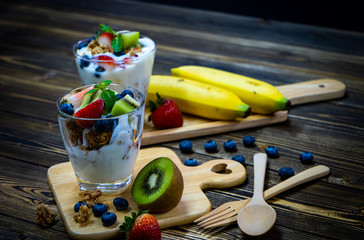 Snacks with yogurt, muesli and fresh berries, fresh kiwi, fresh strawberries,  healthy food and good weight loss.