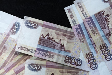 A stack of Russian banknotes of five hundred rubles on a dark background close up