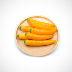 Yellow hot chili pepper in a wooden cup  isolated on the white background.