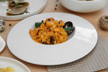 Mediterranean food. Seafood spaghetti with seafood. On a wooden background. beige background