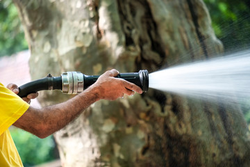Worker Spraying Water From The Hose