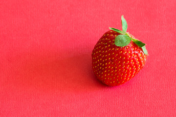 Red strawberry on red background.