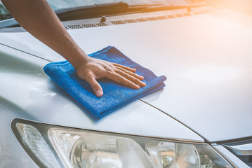 man cleaning car with microfiber cloth