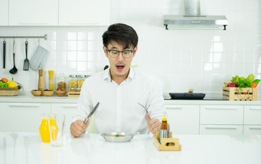 A handsome man is having breakfast in the modern kitchen