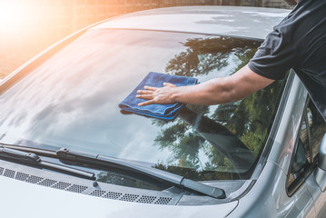 man cleaning car with microfiber cloth