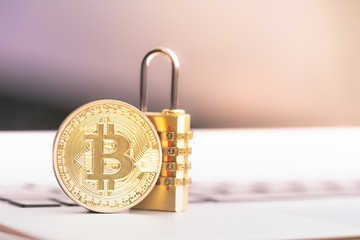 Bitcoin(BTC) coin with padlock lying on computer background. Bitcoin security. digital cyber safety or security encryption, Blockchain technology to encode online information or data protection.