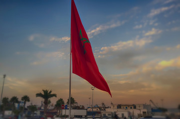 Fototapeta premium The Moroccan national flag with the background of the port of Tangier