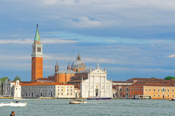 Fototapeta na wymiar Boats flowing between the islands with a beautiful historic church in Venice, Italy.