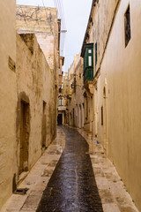 Fototapeta na wymiar Wet, narrow, cobbled streets in Victoria, Gozo, Malta following a heavy rain storm.