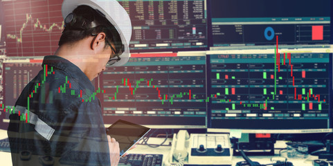 Double exposure of business man or engineer using tablet with stock trading room and stock trading chart background for investment business concept