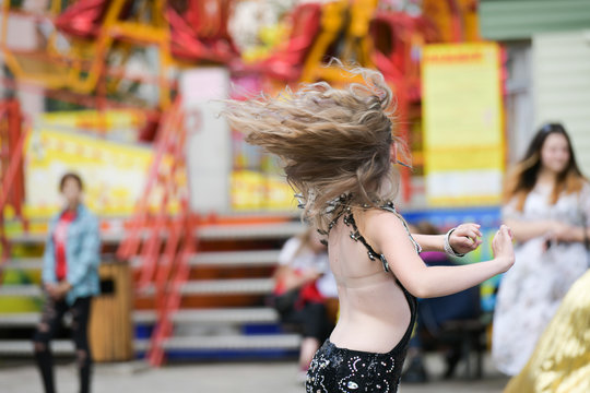 brunette girl dancing on the street. Portrait of a beautiful blonde outdoors in a smart dress, lifestyle.