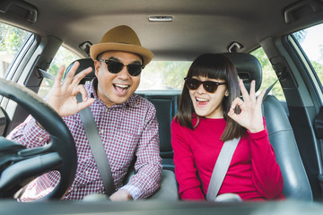 Happy moment couple asian man and woman sitting in car. Enjoying travel concept.