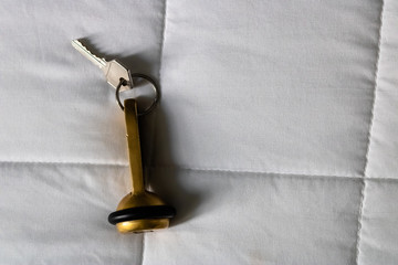 Hotel key laying on the white bed sheets closeup  - Image