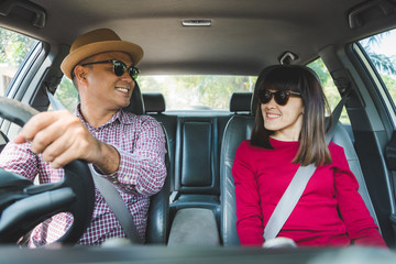 Happy moment couple asian man and woman sitting in car. Enjoying travel concept.
