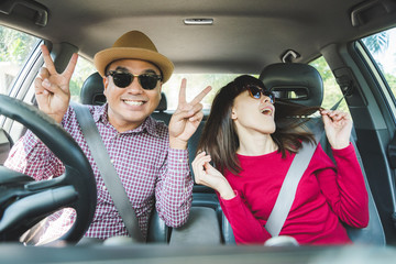 Happy moment couple asian man and woman sitting in car. Enjoying travel concept.