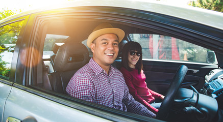 Happy moment couple asian man and woman sitting in car. Enjoying travel concept.
