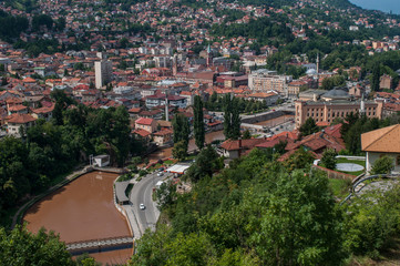 Fototapeta premium Bosnia and Herzegovina: aerial view of the skyline of the capital Sarajevo, surrounded by the Dinaric Alps and situated along the Miljacka River, seen from Zuta Tabija (Yellow Fortress) 