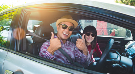 Happy moment couple asian man and woman sitting in car. Enjoying travel concept.