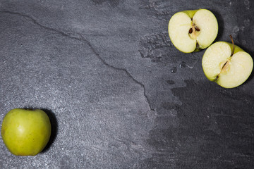 the photo shows green, juicy, fresh apples lying on a dark marble table