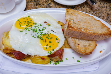 Close up shot of fried sunny egg with grill potato, bread