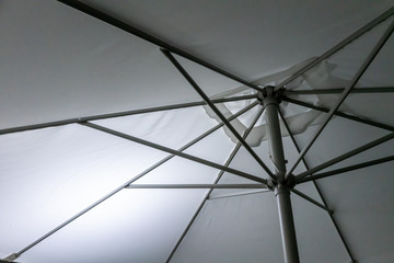 Metal Structure of an umbrella as abstract background. White umbrella with metal lines on a sunny...