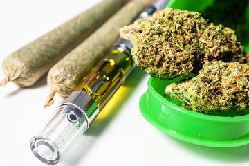 THC Concentrate Oil Vape Pen With Marijuana Herb & Rolled Joints Up Close On White	