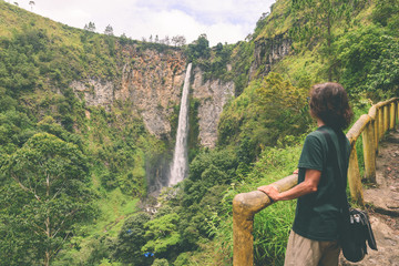 Sipiso-piso waterfall famous travel destination natural landmark and tourist attraction in Berastagi and Lake Toba, Sumatra Indonesia. Tourist looking at view, traveling people, toned.