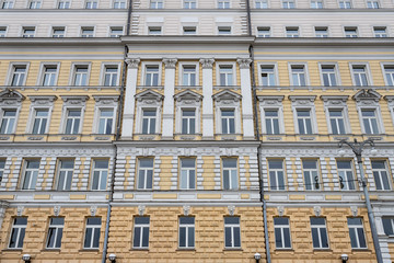 Obraz premium Several Windows in a row on the facade of the old building. Windows in a row on a marble wall. Rows of Windows on a tall building.