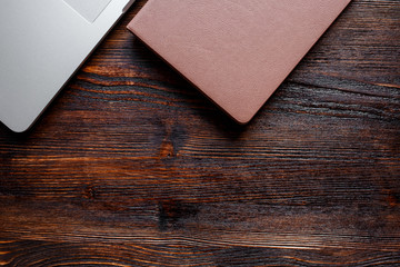 work space of a businessman. view from above . coffee black note and laptop on the desktop with black note. laptop on wooden background