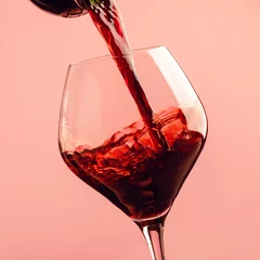 Fotobehang Rood Franse droge rode wijn, giet in glas, trendy roze achtergrond, ruimte voor tekst, selectieve focus