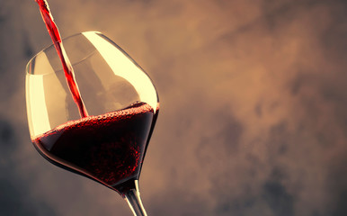 French dry red wine, pours into glass, gray background, selective focus