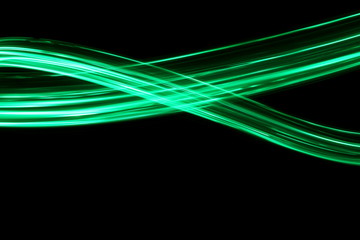 Long exposure, light painting photography.  Vibrant neon green streaks of colour against a black...