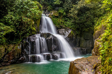 Fototapeta na wymiar Beautiful waterfall at the mountain with blue sky