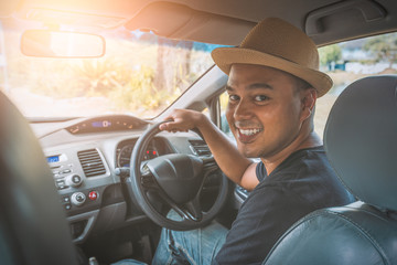 Young handsome asian man driving car