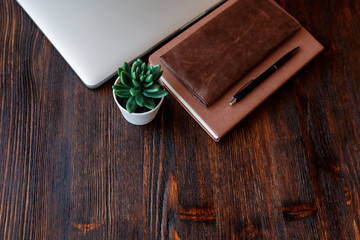 work space of a businessman. view from above . coffee black note and laptop on the desktop with black note. laptop on wooden background