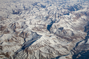 Aerial view from top of Himalayan mountains from the airplane window with Snow cover all of mountain range. Surface of white on peak hill over sky in Leh Ladakh, India.