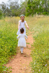 Life moment of happy family. Two sisters playing having fun together on the grass in sunny summer day.