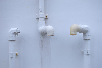 白い壁に使われなくなったパイプ