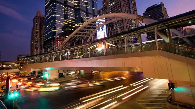 Time-lapse bridge link between BRT and BTS transportation at Chong Nonsi Station in capital city Bangkok, Thailand, dusk to night.