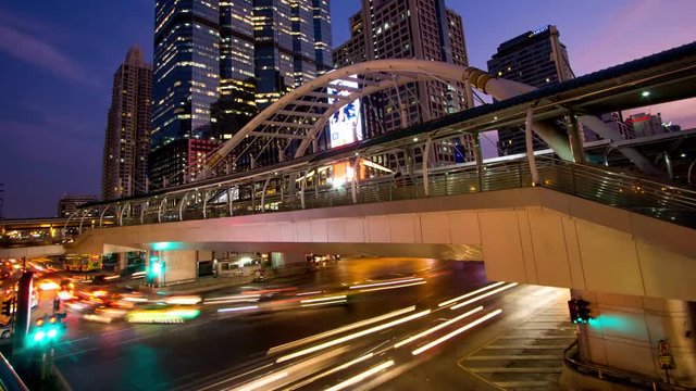 Time-lapse bridge link between BRT and BTS transportation at Chong Nonsi Station in capital city Bangkok, Thailand, dusk to night.