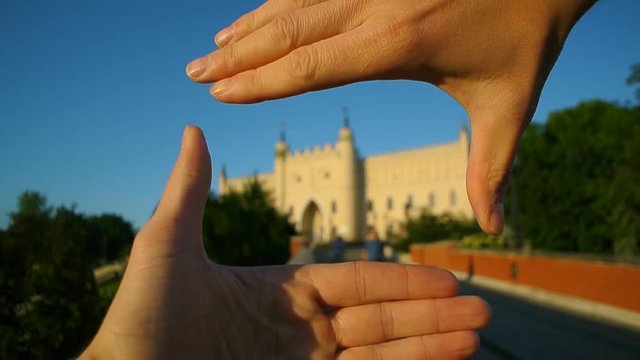 Tourist hands framing Lublin castle popular travel landmark close up unfocused