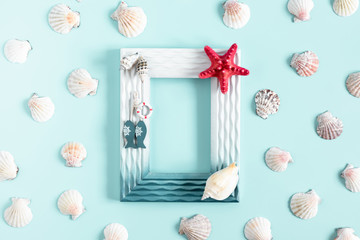 Sea beach composition. Starfish, seashell, photo frame on pastel blue background. Summer concept. Flat lay, top view, copy space