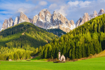 Sunny landscape of Dolomite Alps. St Johann Church with beautiful Dolomiti mountains, Santa Maddalena