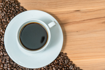 Cup of coffee and coffee beans on wooden background, Vintage tone
